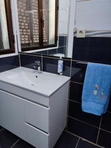 La salle de bains est pourvue d'un lavabo et d'une serviette bleue. dans l'établissement Vivenda Casa da Fraga, à Alijó