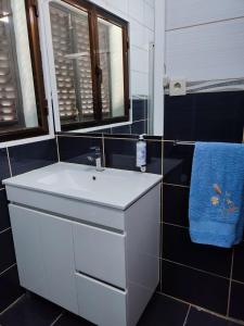 baño con lavabo blanco y toalla azul en Vivenda Casa da Fraga, en Alijó