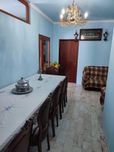 Vivenda Casa da Fraga في آلهيو: غرفة طعام مع طاولة وكراسي وثريا