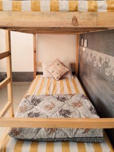 a bunk bed in a small room with a bed sqor at Be Happy HomeStay in McLeod Ganj