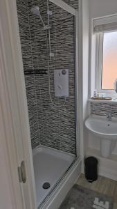 een badkamer met een douche en een wastafel bij The Lancers in Kent