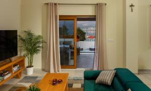 a living room with a green couch and a sliding glass door at Villa Alora in Pridraga