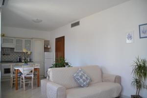salon z kanapą i stołem oraz kuchnia w obiekcie Casa delle Conchiglie w Puli