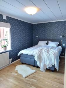 1 dormitorio con 1 cama con pared azul en Fin torparstuga strax utanför Falköping. en Falköping