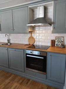 a kitchen with blue cabinets and a stove top oven at Fin torparstuga strax utanför Falköping. in Falköping