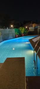 una piscina iluminada por la noche en Luxury 2BHK Apartment Near Candolim en Nerul
