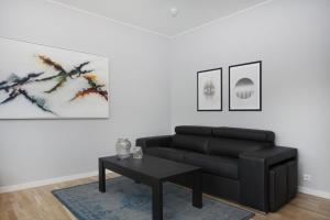 a living room with a black couch and a table at Blue Luxury Apartments in Reykjavík