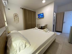 a large white bed in a room with a tv at Anel Studios in Vlorë