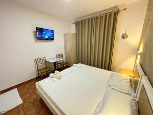 a bedroom with a bed and a tv on the wall at Anel Studios in Vlorë