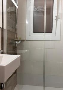 a bathroom with a sink and a glass shower at Apartamentos Wundermar in Torredembarra