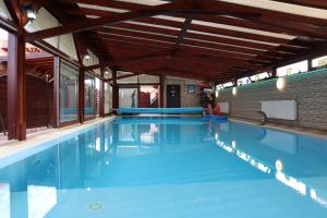 una grande piscina con acqua blu di Barackos Wellness Villa Fót a Fót