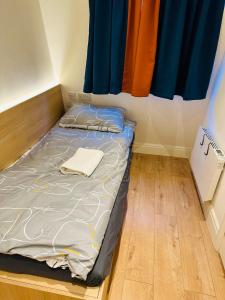 a small bed in a room with a window at Tiny but private & best Location in London