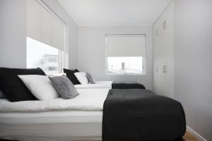 a white bedroom with two beds and a window at Blue Luxury Apartments in Reykjavík