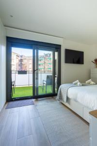 a bedroom with a bed and a large sliding glass door at Gernika Suite in Guernica y Luno