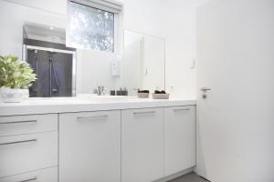 a kitchen with white cabinets and white appliances at Blue Luxury Apartments in Reykjavík