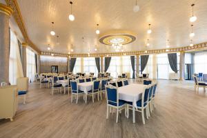 a banquet hall with white tables and blue chairs at Cənnət Məkən Göygöl in Goygol