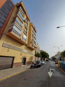 un edificio al lado de una calle con coches aparcados en RAYMAR HOUSE, en Melilla