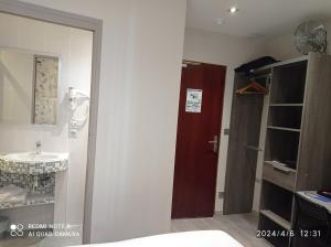a bathroom with a sink and a toilet and a door at Hotel de la Couronne in Aix-les-Bains