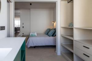 a bedroom with a bed in a room with shelves at Luminoso ático en el centro in Santa Cruz de Tenerife