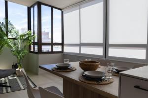 uma cozinha com janelas e uma mesa com pratos em Luminoso ático en el centro em Santa Cruz de Tenerife