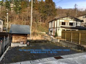two tree parking spaces in a yard with a house at Matsuo House - Max 3 person Room Haru in Zao Onsen