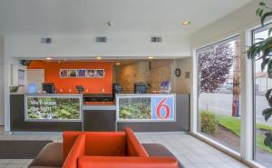 a restaurant with orange chairs and a waiting room at Motel 6-Coos Bay, OR in Coos Bay