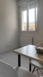 Camera bianca con tavolo, sedie e finestra di La Dimora degli Artisti - Bologna a Bologna