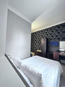 a bedroom with a white bed and a desk at Cathedral Quarter Hotel - Derby in Derby