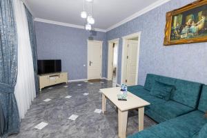 a living room with a blue couch and a table at Cənnət Məkən Göygöl in Goygol