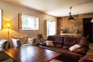 ein Wohnzimmer mit einer Ledercouch und einem Tisch in der Unterkunft Casa Crisa in Marín