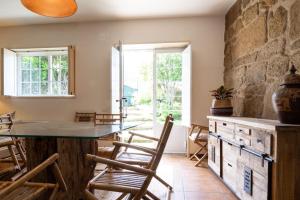 eine Küche mit einer Steinwand und einem Tisch und Stühlen in der Unterkunft Casa Crisa in Marín