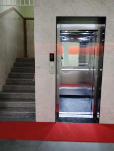 チェンナイにあるSR RESIDENCYの階段のある建物内の開閉式エレベータードア