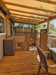 un patio con calentador, mesa y sillas en Camping La Carabasse Vias-Plage - T4 Neuf, Tout Confort !, en Vias