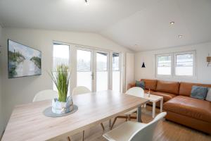a living room with a table and a couch at Ostseecamp Lübecker Bucht Ferienhaus "JU-LI" mit kostenlosen Saunazugang in Scharbeutz