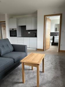 a living room with a couch and a coffee table at Grindal - Executive Apartment Hotel in St Bees