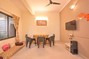 a living room with a table and chairs and a tv at MERCURY VILLA ll 4BHK ll PRIVATE SWIMMING POOL in Lonavala