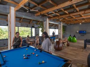 a group of people playing pool in a room with a pool table at The Grand Cliff Resort Munnar in Viripara