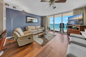 sala de estar con sofá y TV de pantalla plana en Long Beach Resort 4-902, en Panama City Beach