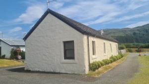 a small white building with a pitched roof at Hawthorn Self Catering Cottages in Benderloch