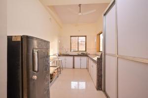 a kitchen with a black refrigerator in a room at MERCURY VILLA ll 4BHK ll PRIVATE SWIMMING POOL in Lonavala