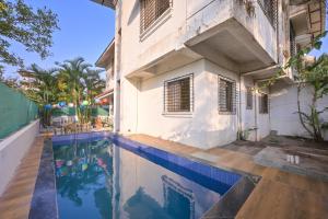 a house with a swimming pool next to a building at MERCURY VILLA ll 4BHK ll PRIVATE SWIMMING POOL in Lonavala