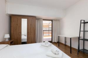 1 dormitorio con cama, escritorio y ventana en ApartEasy - Atic Sants, en Barcelona
