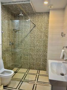 a bathroom with a shower and a toilet and a sink at Holiday Premium Apartments Batumi in Batumi