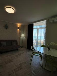 a living room with a glass table and a couch at Holiday Premium Apartments Batumi in Batumi