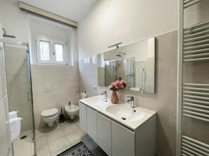 een badkamer met een wastafel, een toilet en een spiegel bij Casa Felicity Verona in Verona