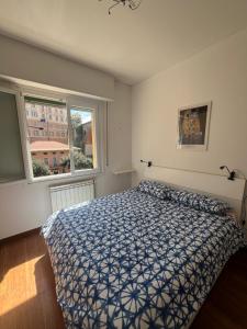 - une chambre avec un lit avec une couette bleue et 2 fenêtres dans l'établissement Un balcone sul mare, à Sori