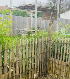une clôture en bois en face d'un jardin dans l'établissement Rue des roses, à Saint-Pierre-dʼOléron