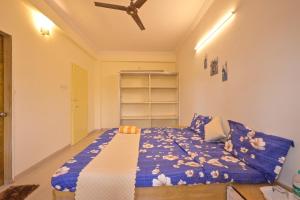 a bedroom with a bed with a blue comforter at MERCURY VILLA ll 4BHK ll PRIVATE SWIMMING POOL in Lonavala