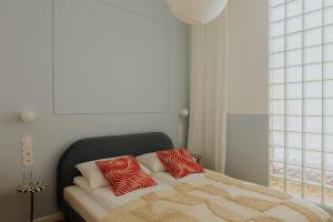 a bed with two red pillows on top of it at Apartments Floriańska 24 in Krakow