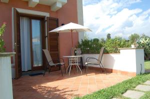 a patio with a table and an umbrella at Apartment mit Terrasse - b57363 in Acireale
